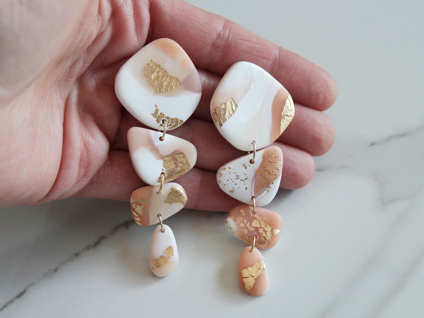 Bold gold leaf earrings with unique geometric shapes in soft pastel hues from Alma Rosa Jewelry