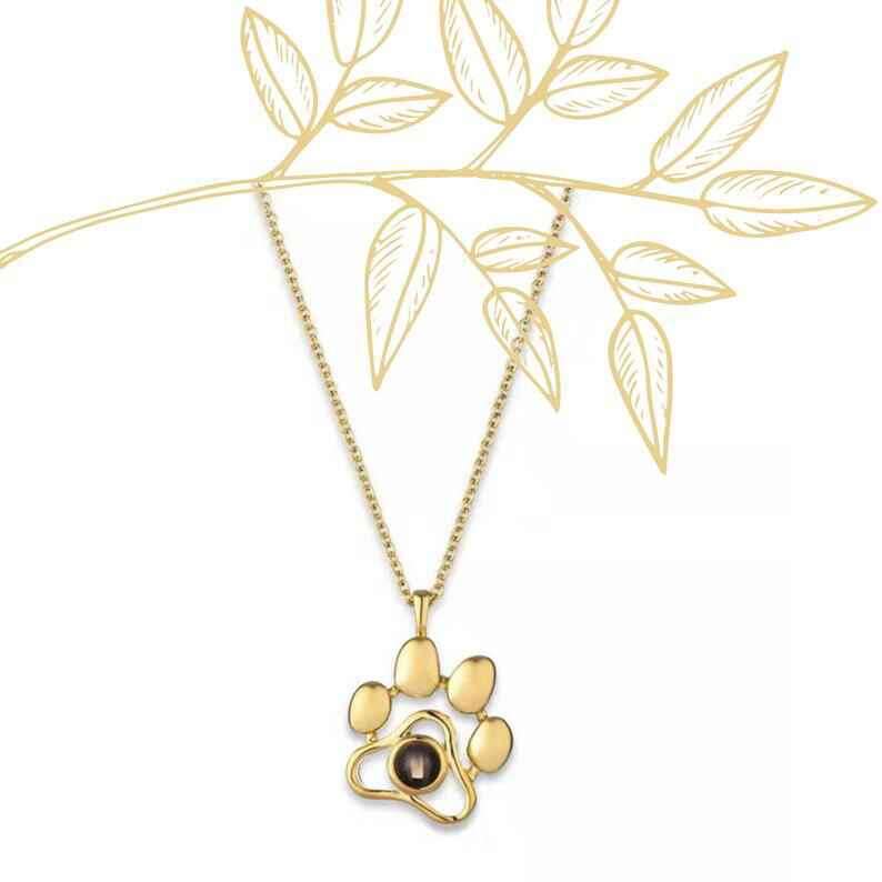 Gold paw print necklace featuring a custom pet photo necklace design with a gemstone centerpiece