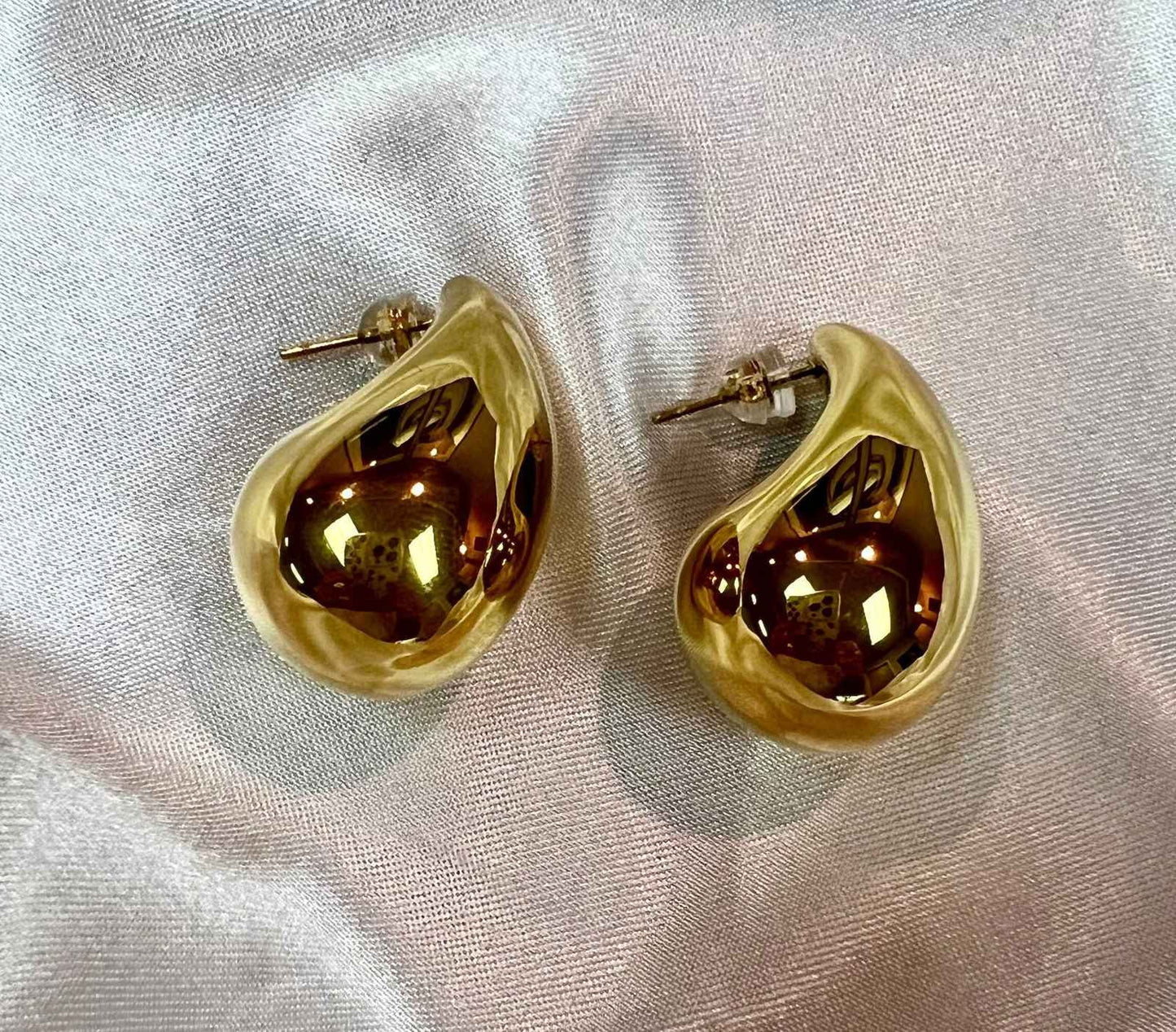 Unique gold earrings with a sleek teardrop design, perfect for stylish occasions