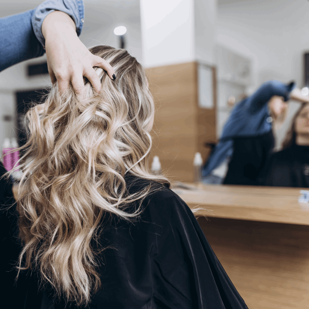 A stylist applying Aloe Essence Shampoo with Vitamin E on client in a salon setting