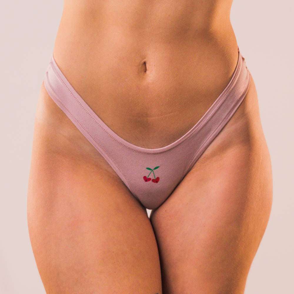 Cheeky Cherry leakproof thong liner in soft pink with a cute cherry design for comfort and style
