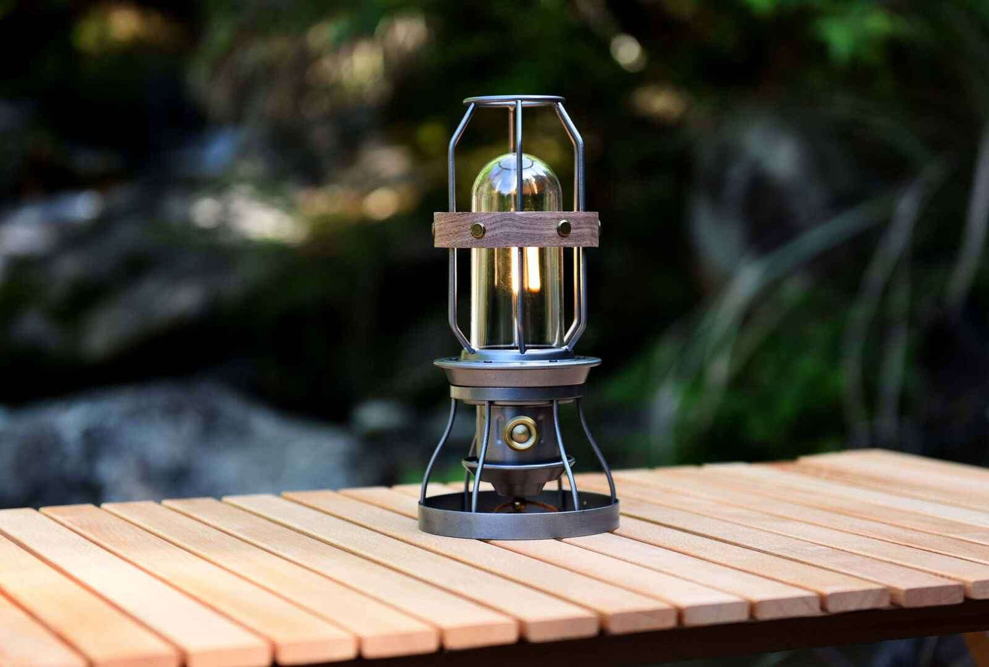 Vintage grey camping lantern by Peterson Housewares & Artwares on a wooden table outdoors
