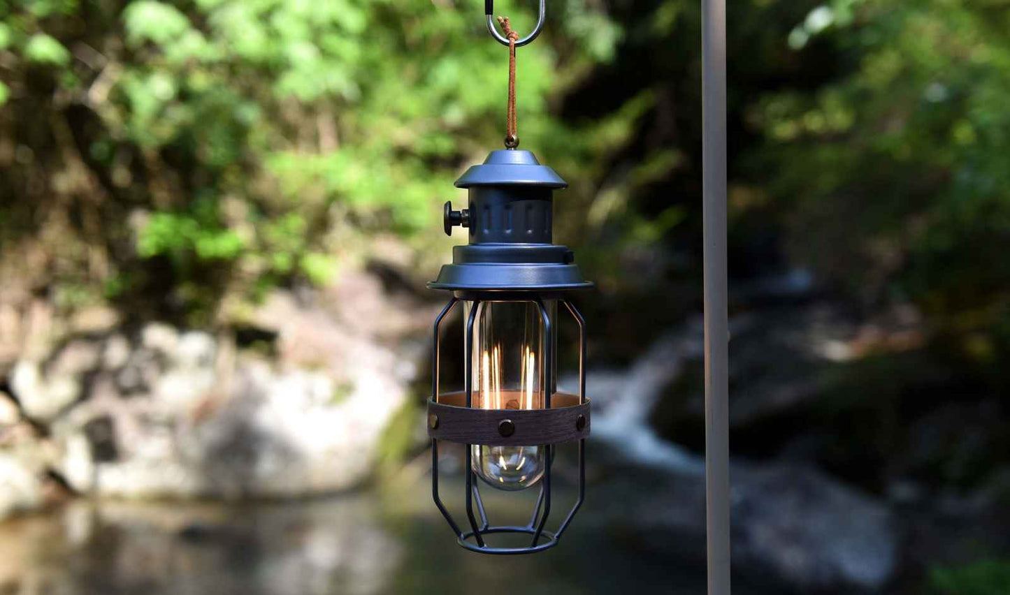 Vintage grey camping lantern with a glass globe and metal frame, ideal for outdoor adventures