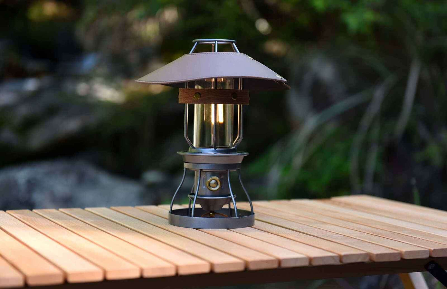Vintage grey camping lantern by Peterson Housewares & Artwares on a wooden table in a natural setting