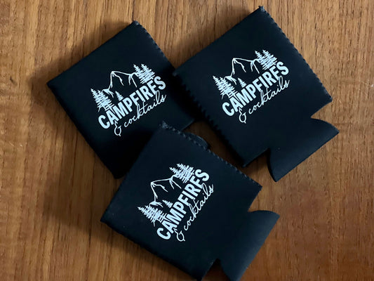 Set of three black campfire koozies featuring playful mountain designs and cocktail text