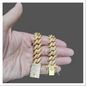 Gold Cuban link bracelet featuring a bold design and sparkling accents held in a hand