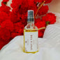 Heav Nation Citrus Body Spray in a clear bottle with a spray nozzle, surrounded by red flowers