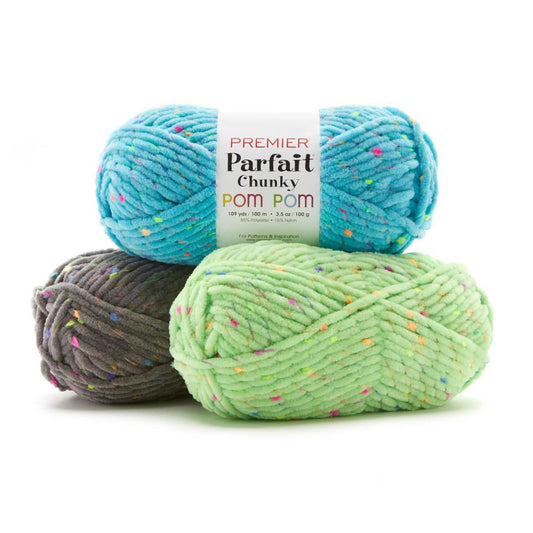 Premier Parfait Pom yarn in three colors: bright blue, green, and gray for crochet and knitting projects