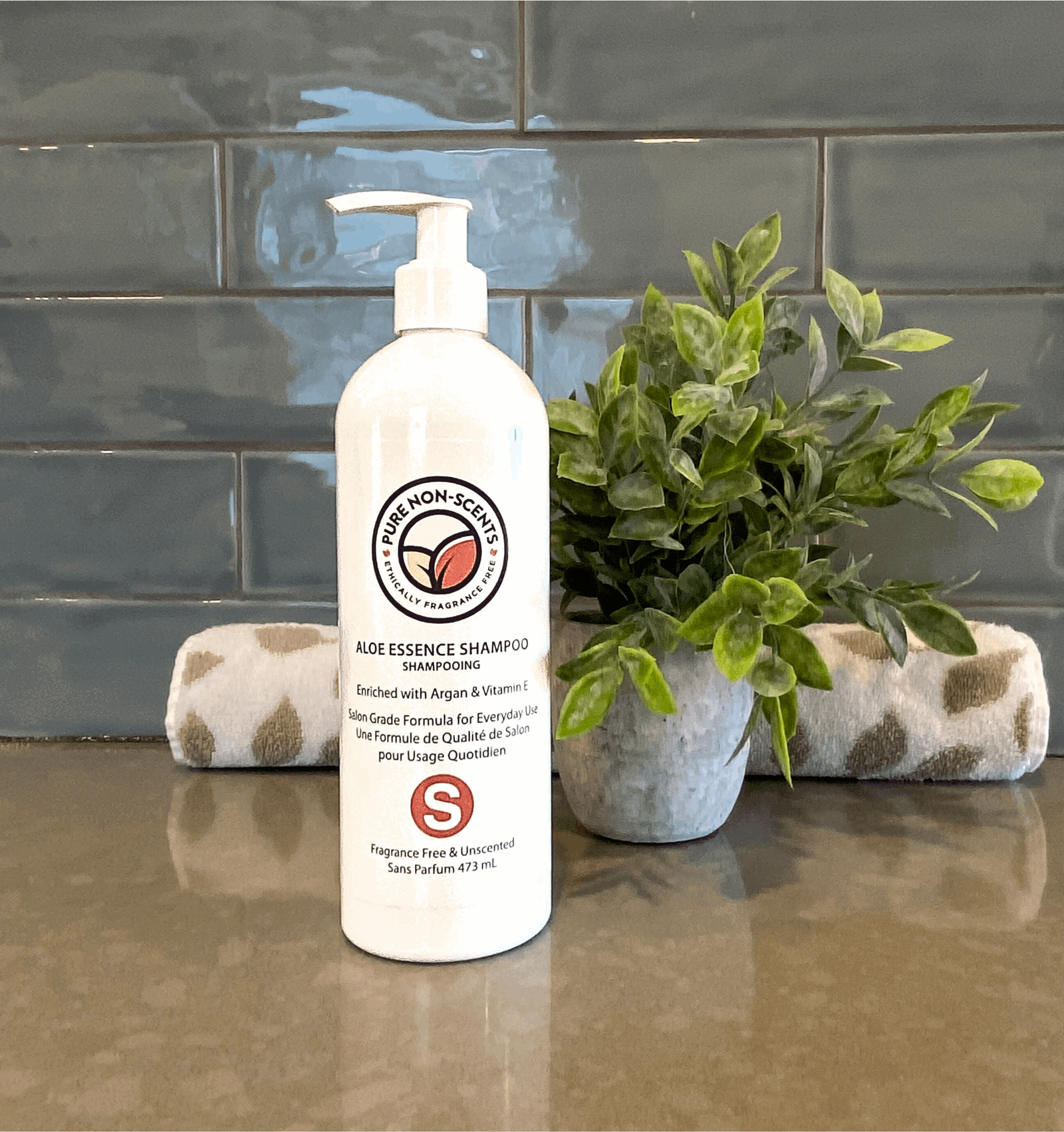 Pure Non-Scents Aloe Essence Shampoo with Vitamin E in a bottle on a bathroom counter with a plant