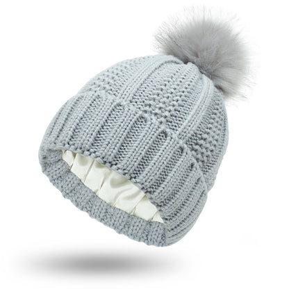 Bonnet en laine doublé de satin avec pompon en fausse fourrure