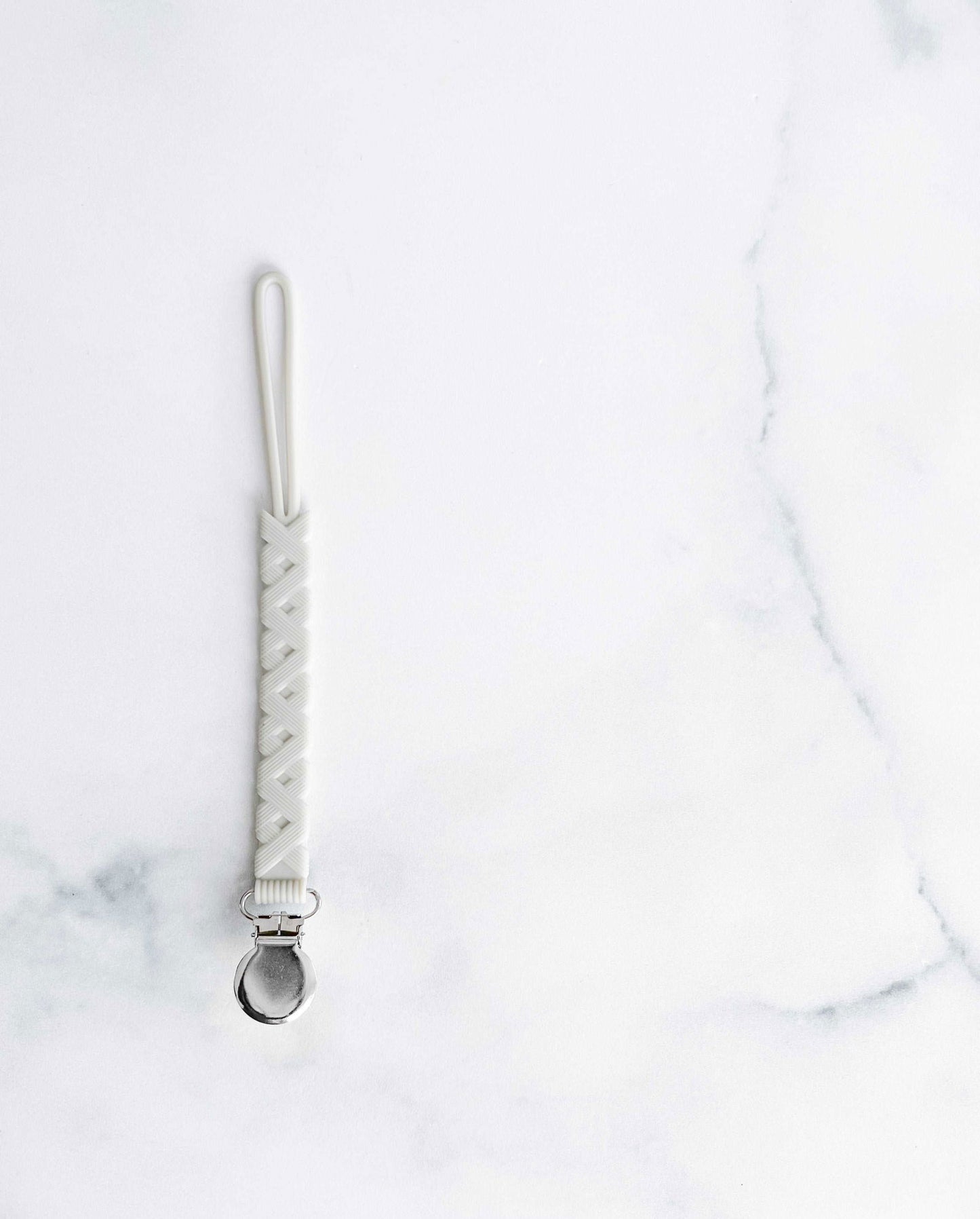 Creation Coco Lyly white silicone pacifier holder with a secure clip for easy attachment