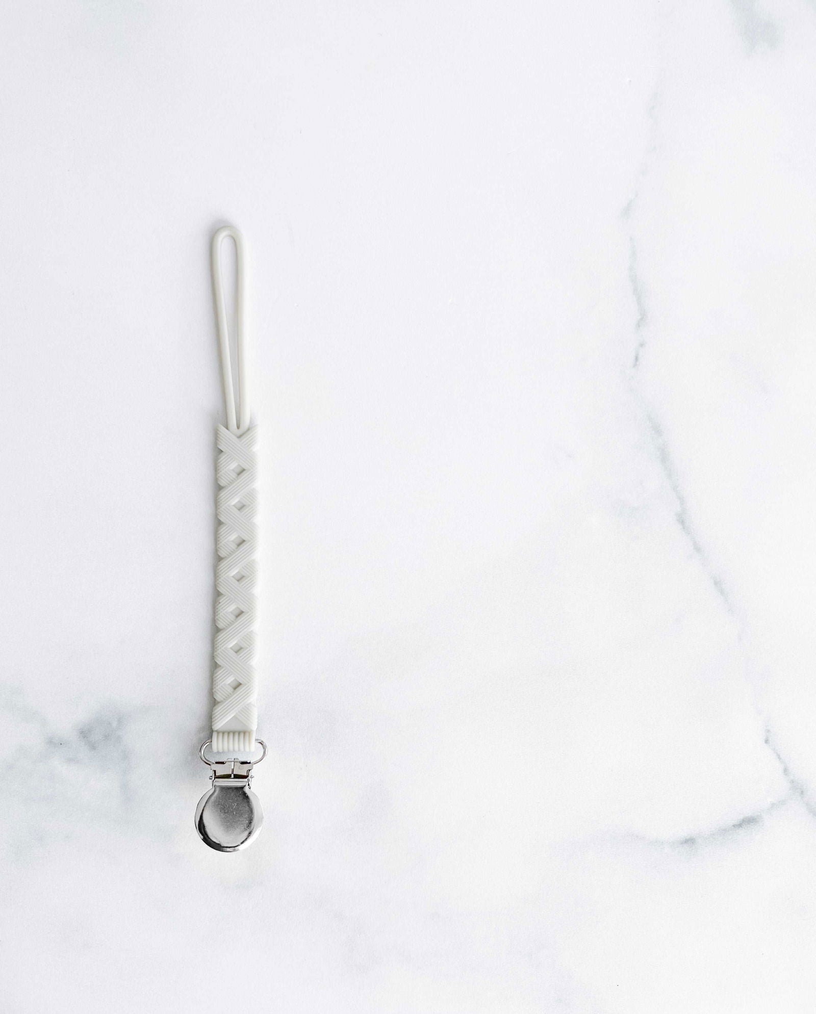 Creation Coco Lyly white silicone pacifier holder with a secure clip for easy attachment