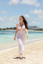 Elegant white stylish maxi dress worn on the beach for a fashionable summer look