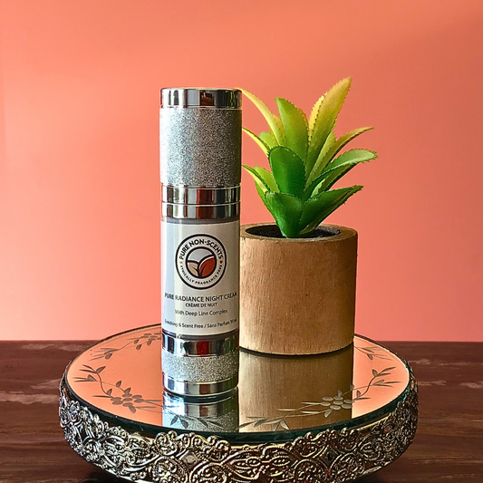 Pure Non-Scents Pure Radiance Night Cream in a silver and white bottle with a plant backdrop