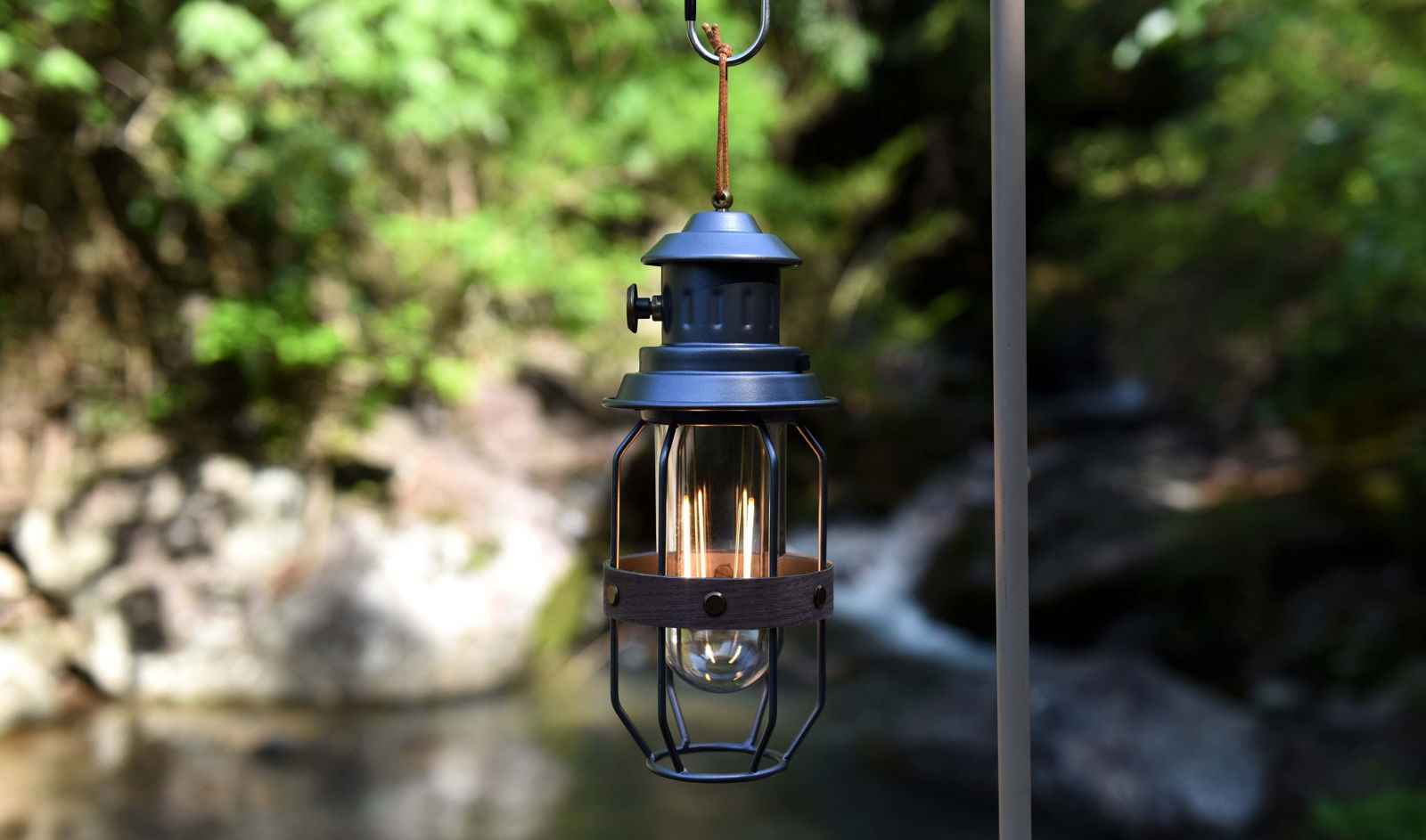 Vintage grey camping lantern with a glass globe and metal frame, ideal for outdoor adventures