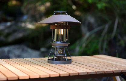 Vintage grey camping lantern by Peterson Housewares & Artwares on a wooden table in a natural setting