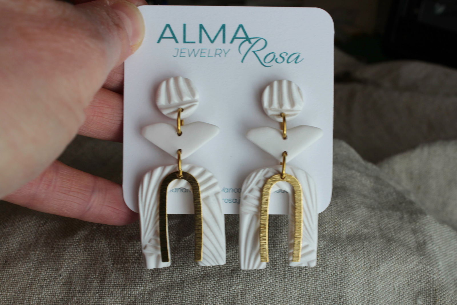 Elegant white polymer clay earrings by Alma Rosa Jewelry featuring unique shapes and gold accents